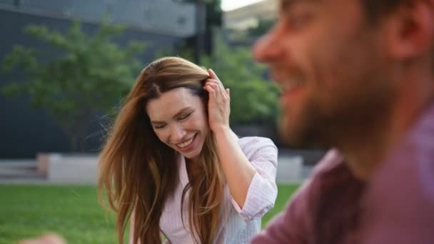 Flirtování dívka těší rande dotýkání vlasy detailní. Šťastný pár pije kávu odpočívající na pikniku v městském parku. Atraktivní ležérní žena se směje jako vousatý přítel. Radostní přátelé tráví víkend - Záběry, video