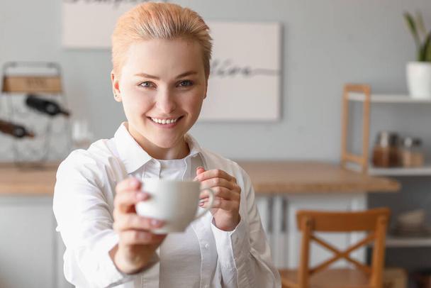 Mujer joven con taza de café en la cocina, primer plano - Foto, imagen