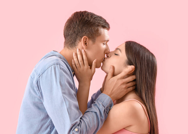 Onnellinen nuori pari suudella vaaleanpunainen tausta, lähikuva - Valokuva, kuva