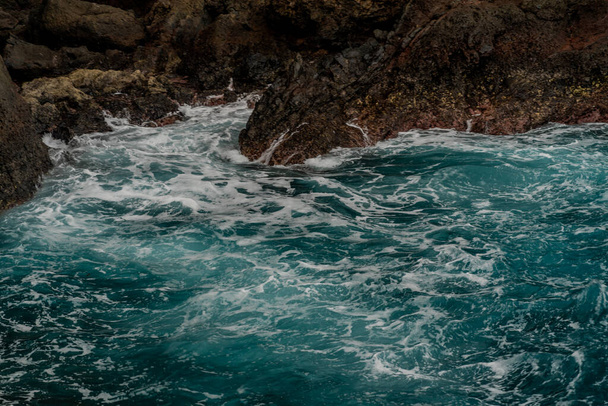 Onde che si infrangono sulla riva rocciosa dell'isola di Madeira - Foto, immagini