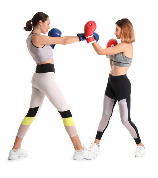 Giovani donne in guanti da boxe formazione su sfondo bianco. Concetto di autodifesa - Foto, immagini