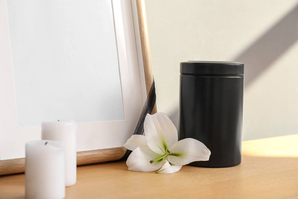 Mortuary urn, candles and lily flower on wooden table, closeup - Photo, Image
