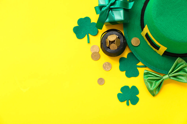 Potje met gouden munten, kabouter hoed en geschenkdoos op gele achtergrond. St. Patrick 's Day viering - Foto, afbeelding