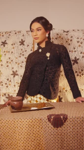 Elegant woman in vintage attire posing with a thoughtful expression in a retro-styled interior during the day - Footage, Video