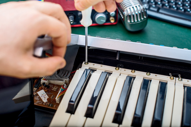 Чоловіча рука фіксує контролер Midi клавіатури
. - Фото, зображення