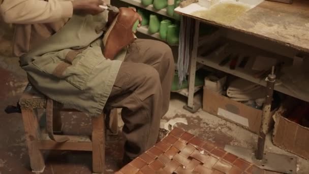 Нахилений знімок молодого чорного взуття, використовуючи плоскогубці, роблячи чоботи в майстерні скеплетів - Кадри, відео