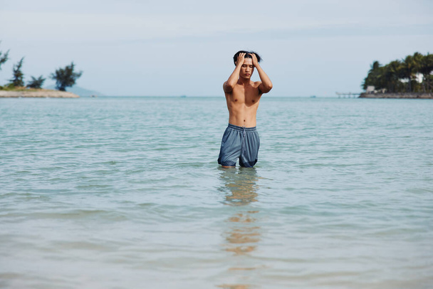 Активный азиат развлекается на солнце, купаясь в Тихом океане - Фото, изображение