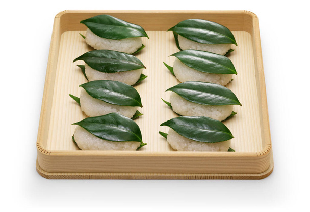 Το Τσουμπάκι Μότσι είναι το παλαιότερο γλυκό της Ιαπωνίας. Ένα κολλώδες κέικ ρυζιού γεμάτο με ζαχαρωμένη πάστα φασολιών αλείφεται ανάμεσα σε δύο φρέσκα φύλλα καμέλιας.. - Φωτογραφία, εικόνα