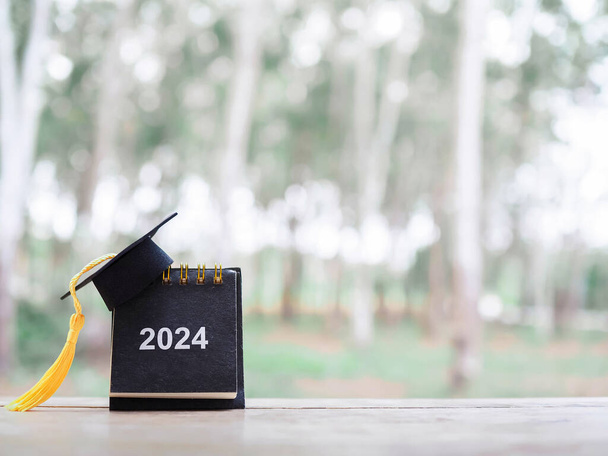 Objetivos do estudo, 2024 Desk calendar with graduation hat. O conceito de Resolução, Objetivo, Ação, Planejamento, e gerenciar o tempo de pós-graduação de sucesso. - Foto, Imagem
