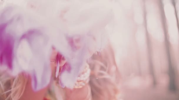 Boho girl blowing pink feathers - Кадри, відео