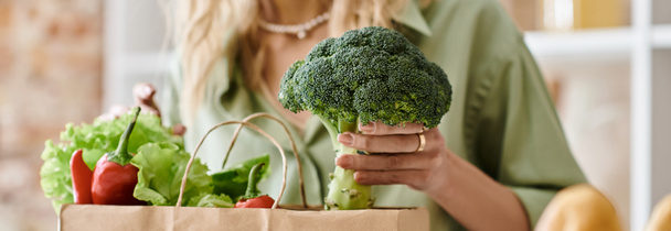 Una mujer en un apartamento sosteniendo una bolsa llena de verduras frescas. - Foto, Imagen