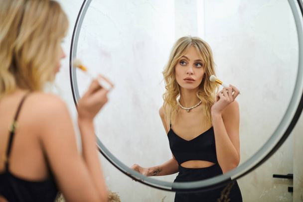 Applying makeup in mirror reflection - Photo, Image