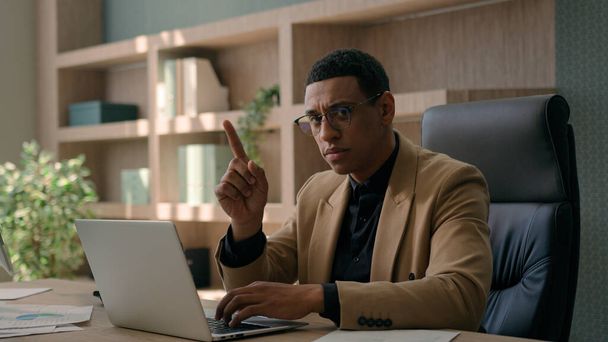Африканський американський етнічний чоловік серйозний бізнесмен, який працює в Інтернеті на ноутбуці в офісі незадоволений чоловік інвестор бізнес-роботодавець махаючи індекс палець негативної позиції не відкидає заборони - Фото, зображення