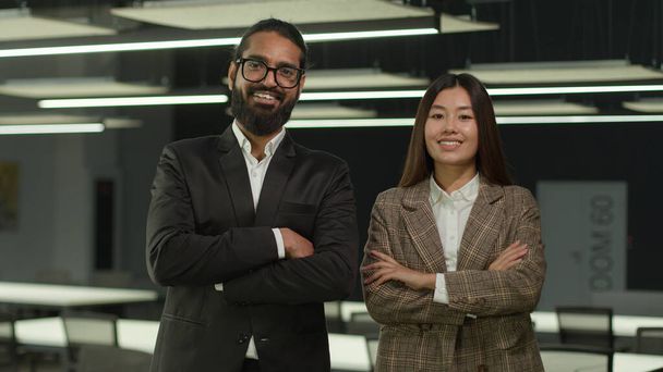 Portré többnemzetiségű üzletemberek állnak az irodában csapatmunka két különböző munkatársak alkalmazottak munkatársak indiai üzletember arab férfi és ázsiai üzletasszony koreai nő pózol kéz keresztbe - Fotó, kép