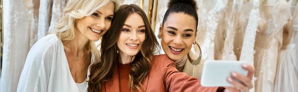 Üç kadın, genç ve güzel bir gelin, annesi ve en iyi arkadaşı cep telefonuyla selfie çekiyorlar.. - Fotoğraf, Görsel