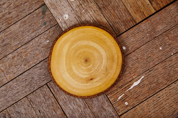 Primer plano de una rebanada de madera con anillos de árboles concéntricos en una superficie rústica de tablón, que ilustra la belleza natural y la sostenibilidad, Fort Wayne, Indiana, 2015. - Foto, Imagen