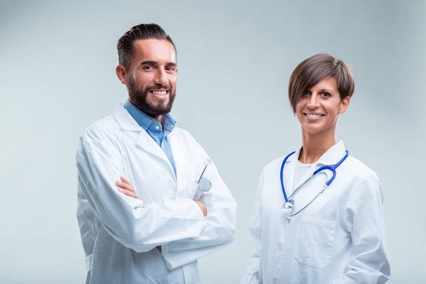 Lääkintäryhmän jäsenet seisovat ylpeinä, heidän ammatillinen pukunsa ja stetoskoopit osoittavat valmiutta palvella - Valokuva, kuva