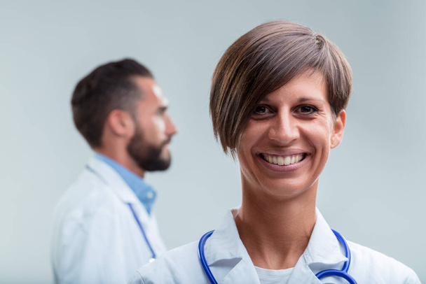 Жінка-професіонал охорони здоров'я стоїть на першому місці, її привітальна посмішка свідчить про досвід і доступність - Фото, зображення