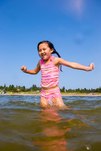 Chica feliz jugando y divirtiéndose en la playa - Foto, Imagen