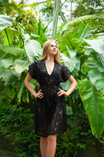 Schöne junge Frau trägt Sommerkleidung in tropischem Resort - Foto, Bild