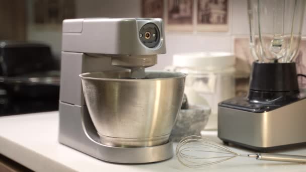 Een elektrische standmixer mengt en kneed de ingrediënten in de keuken. Thuis koken concept. Hoge kwaliteit 4k beeldmateriaal - Video