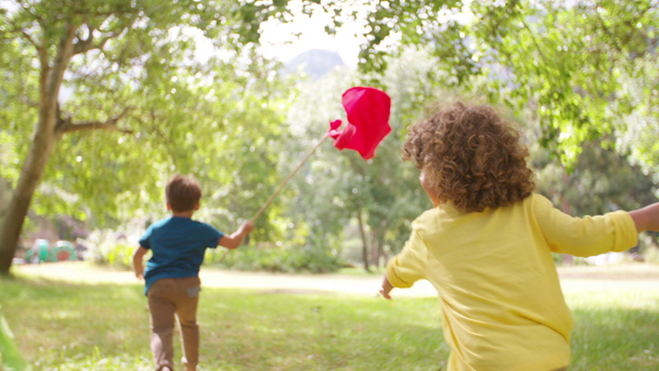 Niños corriendo en el parque con pancartas de colores
 - Imágenes, Vídeo