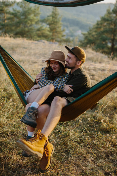 Un couple amoureux sont câlins tout en étant couché dans un hamac dans la nature. - Photo, image