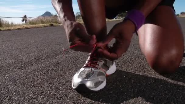 African American runner tying his laces - Filmati, video