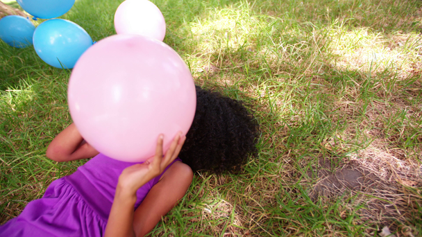 Afro dziewczyny gry z balonów na trawie - Materiał filmowy, wideo