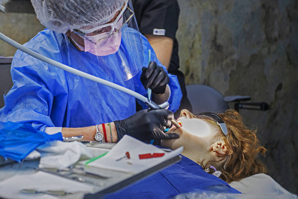 Dentalturbinenhandstück in den Händen eines Zahnarztes während der zahnärztlichen Behandlung eines Patienten - Foto, Bild