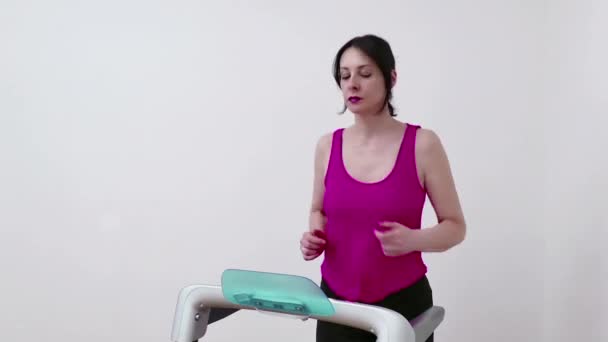 Młoda kobieta ćwiczy i utrzymuje formę na bieżni w domu, Video Clip 4K - Materiał filmowy, wideo