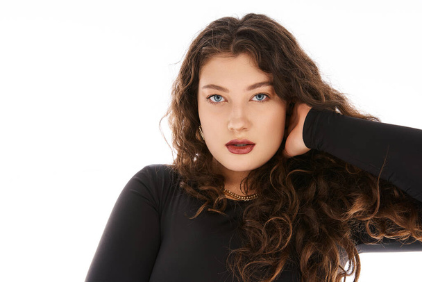 portrait of curvy woman in her 20s with curly hair, blue eyes and hand behind head - Photo, Image