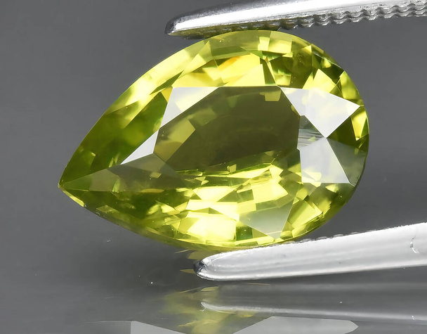 természetes zöld peridot chrysolite drágakő a háttérben - Fotó, kép