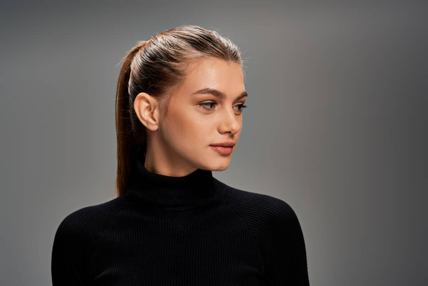 Young woman with long hair wearing a black turtleneck sweater exudes elegance and style. - Fotoğraf, Görsel