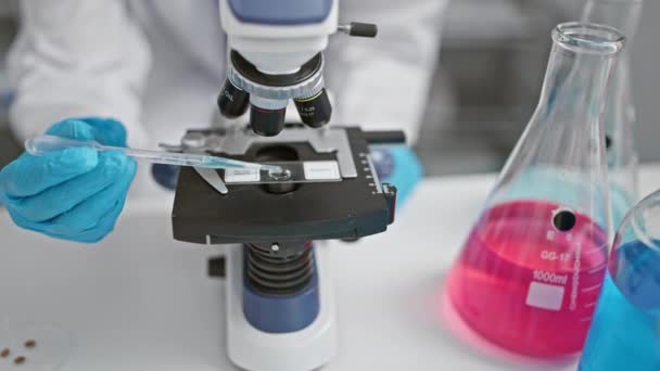 Scientifique utilisant un microscope en laboratoire avec béchers et pipette présents. - Séquence, vidéo