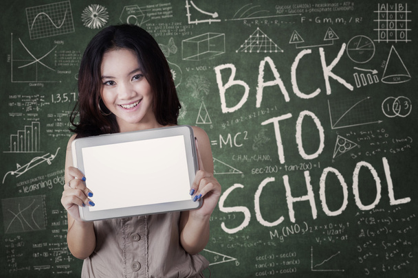 Attractive schoolgirl with tablet in class - Zdjęcie, obraz