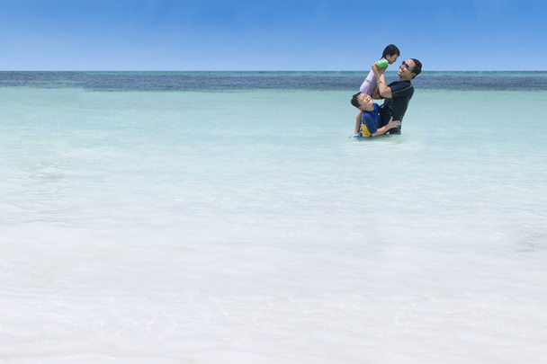 Children and father having fun on beach - Foto, Imagem