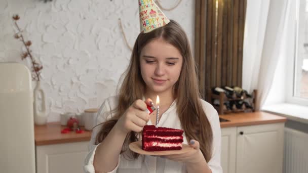 Cumpleaños chica soplando velas en un pastel en el estudio sobre un fondo de un globo. - Metraje, vídeo