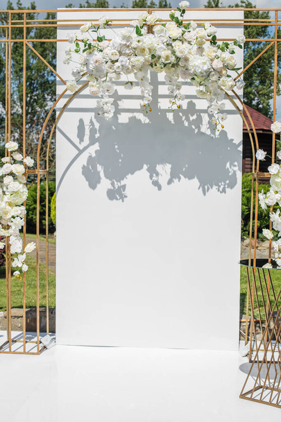 Arco de boda contemporáneo adornado con un elegante arreglo de flores blancas, creando un escenario perfecto para la ceremonia. - Foto, Imagen