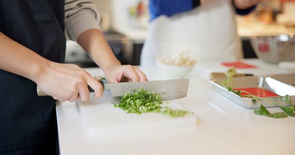 Šéfkuchař ruce, nůž a jarní cibule v restauraci, sekání a připravit ingredience pro cateringové služby. Osoba, krájení zeleniny a vaření potravin pro dietu, výživu a zdraví v Japonsku Tokio. - Fotografie, Obrázek