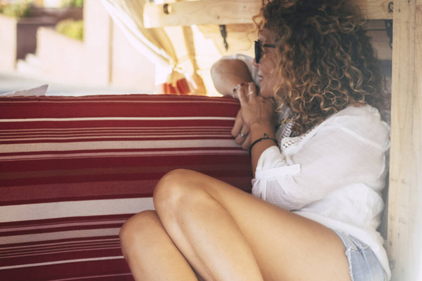 Ελκυστική μελαχρινή ταξίδια γυναίκες άνθρωποι κάθονται μέσα σε ένα μικρό ζεστό ρετρό minivan κοιτάζοντας έξω - έννοια της νεαρής γυναίκας και εναλλακτικές διακοπές ή τον τρόπο ζωής μέσα σε ένα vintage χειροποίητα van - Φωτογραφία, εικόνα