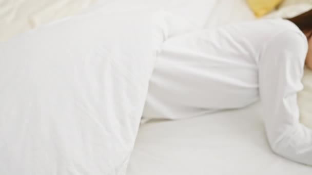 Donna asiatica che dorme tranquillamente in una camera da letto luminosa, incarnando tranquillità e relax a casa. - Filmati, video