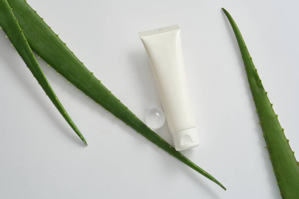 化粧品包装デザインのためのブランドのないプラスチックチューブモックアップは,白い背景にアロエベラの葉とガラスボールを装飾しました. 健康な肌と髪のための自然なアロエベラスキンケア製品. - 写真・画像