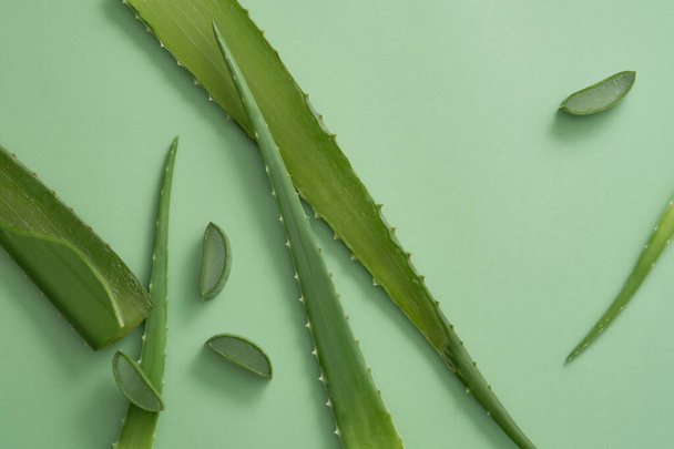 新鮮なアロエベラの葉と緑の背景にスライスのトップビュー. 天然成分のコピースペース付き広告シーン - アロエバルデシス - 写真・画像