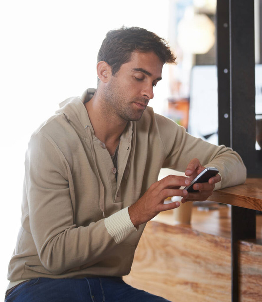 Telefon, síť a mladý muž v kavárně na sociálních sítích, mobilní aplikace nebo internet u stolu. Technologie, čtení a mužské osoby svitek na webových stránkách s mobilním telefonem v restauraci nebo kavárně - Fotografie, Obrázek