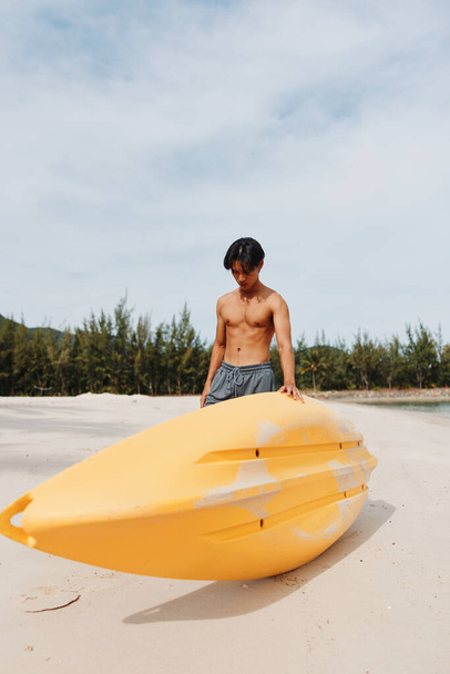 Kayak Fun: Hombre asiático disfrutando de unas vacaciones activas en la playa con remo y canoa en Tropical Paradise - Foto, imagen
