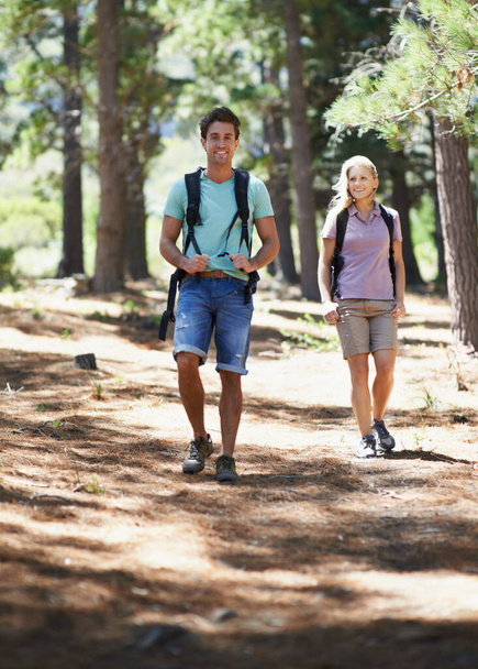 Paar vrienden, reizen en wandelen in het bos voor fitness, outdoor avontuur en wellness of gezondheid in de natuur. Portret van een gelukkige man en vrouw wandelen en wandelen met rugzak op pad en reis. - Foto, afbeelding