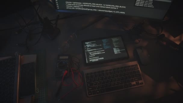 Top view of white html code running on black background at computer and digital tablet displays on desk at night military control department workplace - Záběry, video