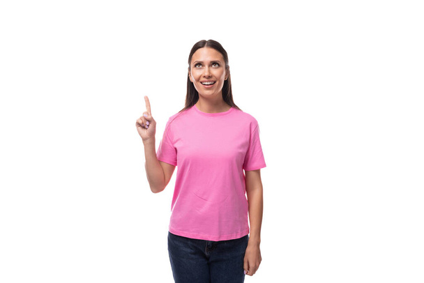 giovane donna bruna caucasica sottile in una t-shirt rosa su uno sfondo bianco con spazio copia. - Foto, immagini