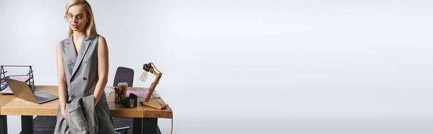 κομψή όμορφη επιχειρηματίας σε εκλεπτυσμένο γκρι κοστούμι με ξανθά μαλλιά κοιτάζοντας μακριά, πανό - Φωτογραφία, εικόνα
